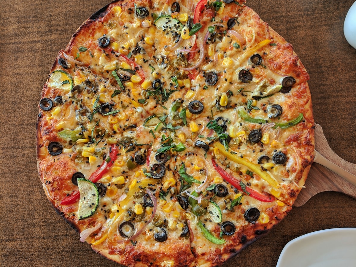 Pizza con verdure e ingredienti a scelta su tagliere di legno
